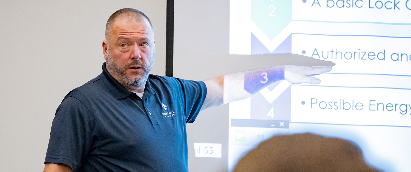 OSHA instructor presenting slide in a training room.