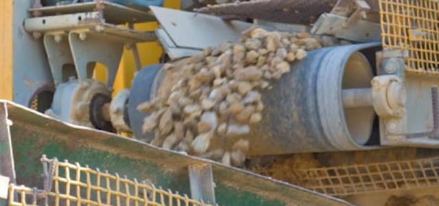 Conveyor belt and rocks moving on industrial equipment with guarding in place