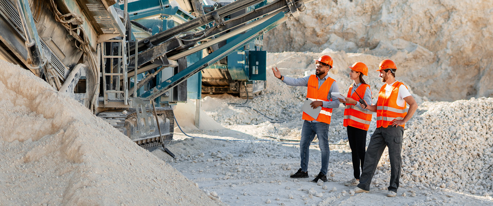 Photo of workers at a surface mining operation wearing hard hats and high visibility vests