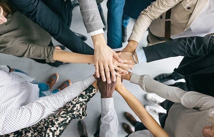Looking down on a group of hands stacked on top of each other.