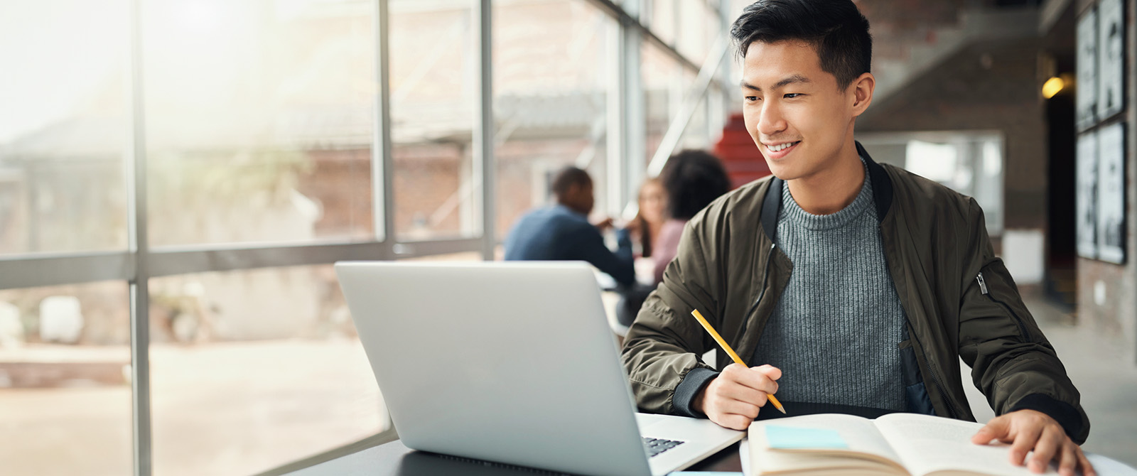 Student studying with laptop in an open campus workspace