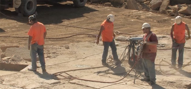A group of miners in hard hats working on site