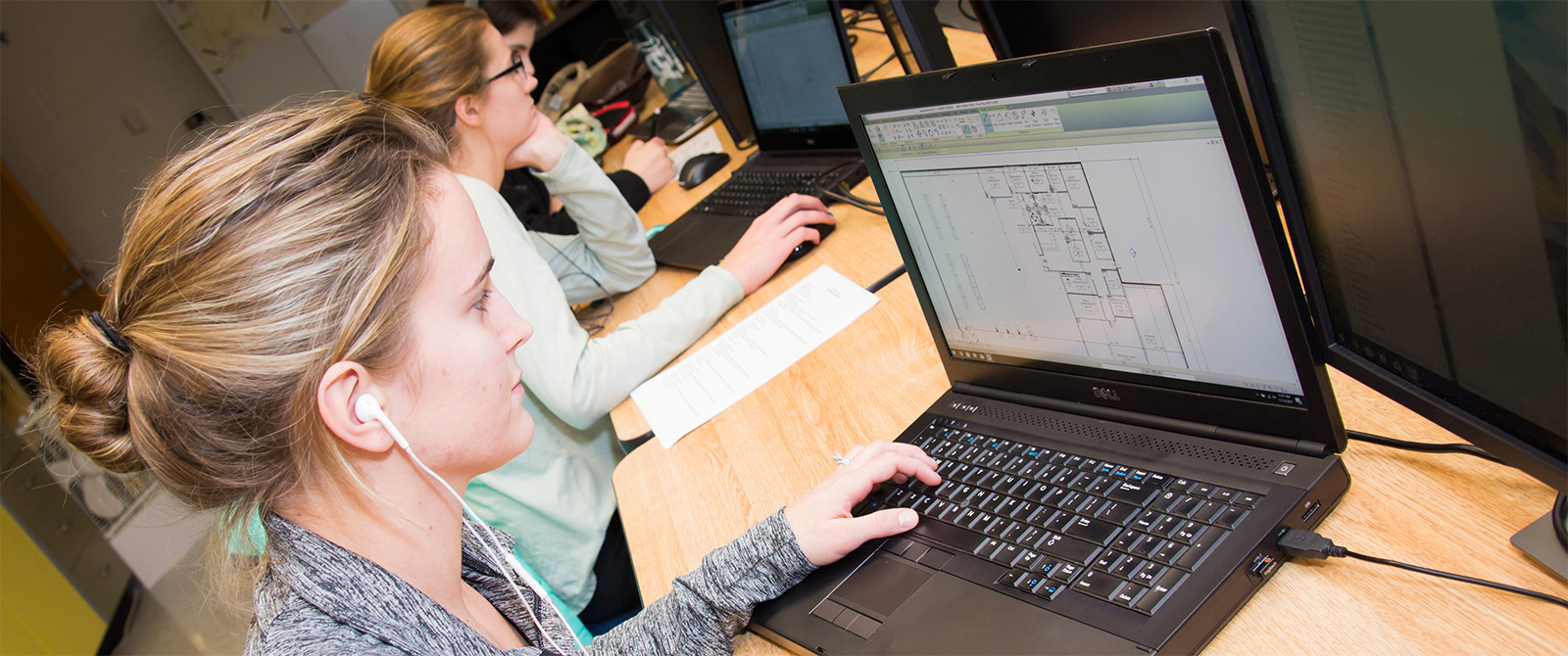 Classroom with Architectural Drafting and Design student working on computer that shows a floor plan