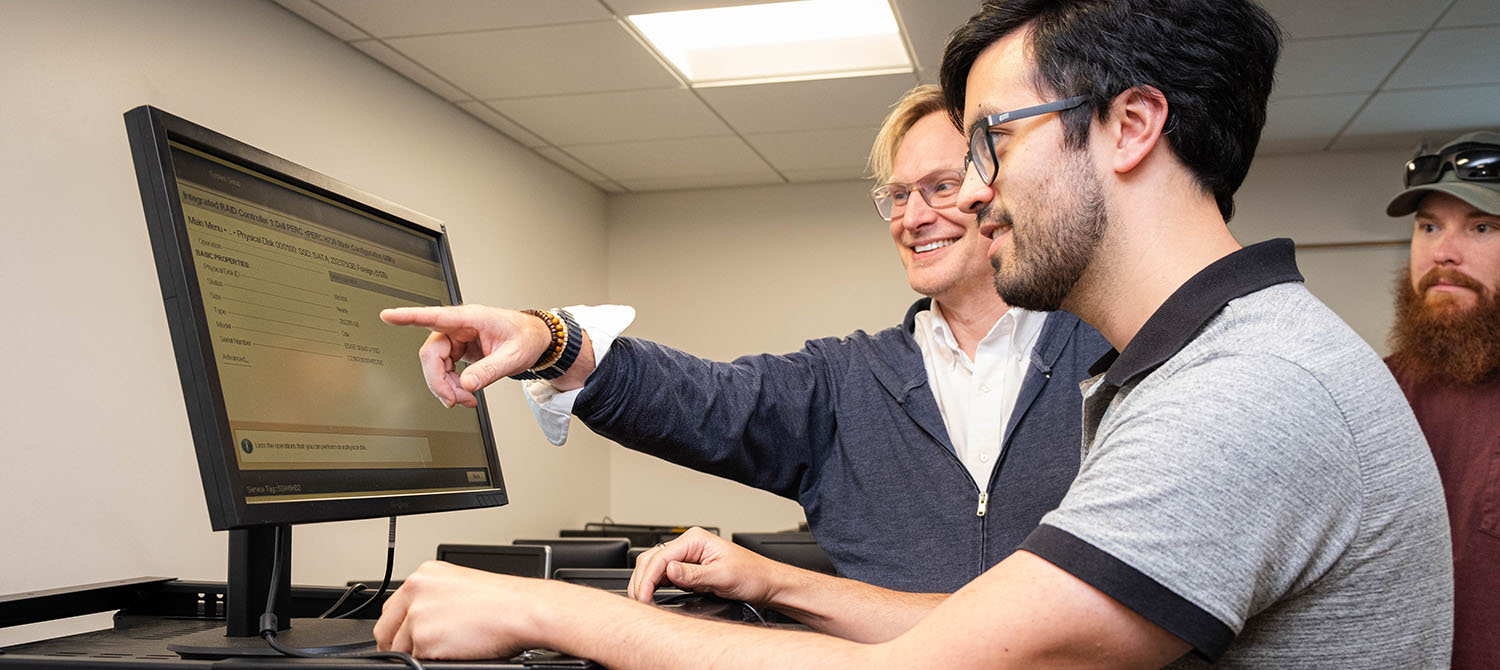 Students and instructor working together to configure network settings using a computer