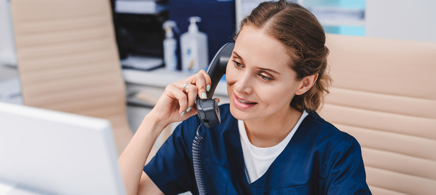 Photo of medical assistant helping a patient on the phone