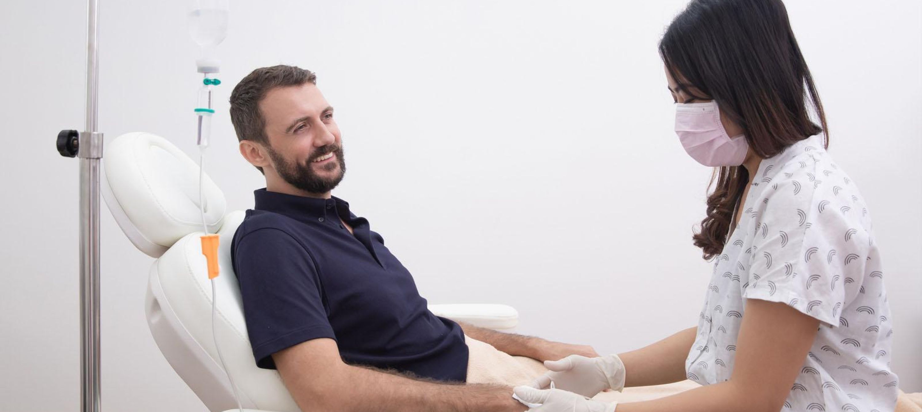 Photo of nurse setting up an IV for waiting patient