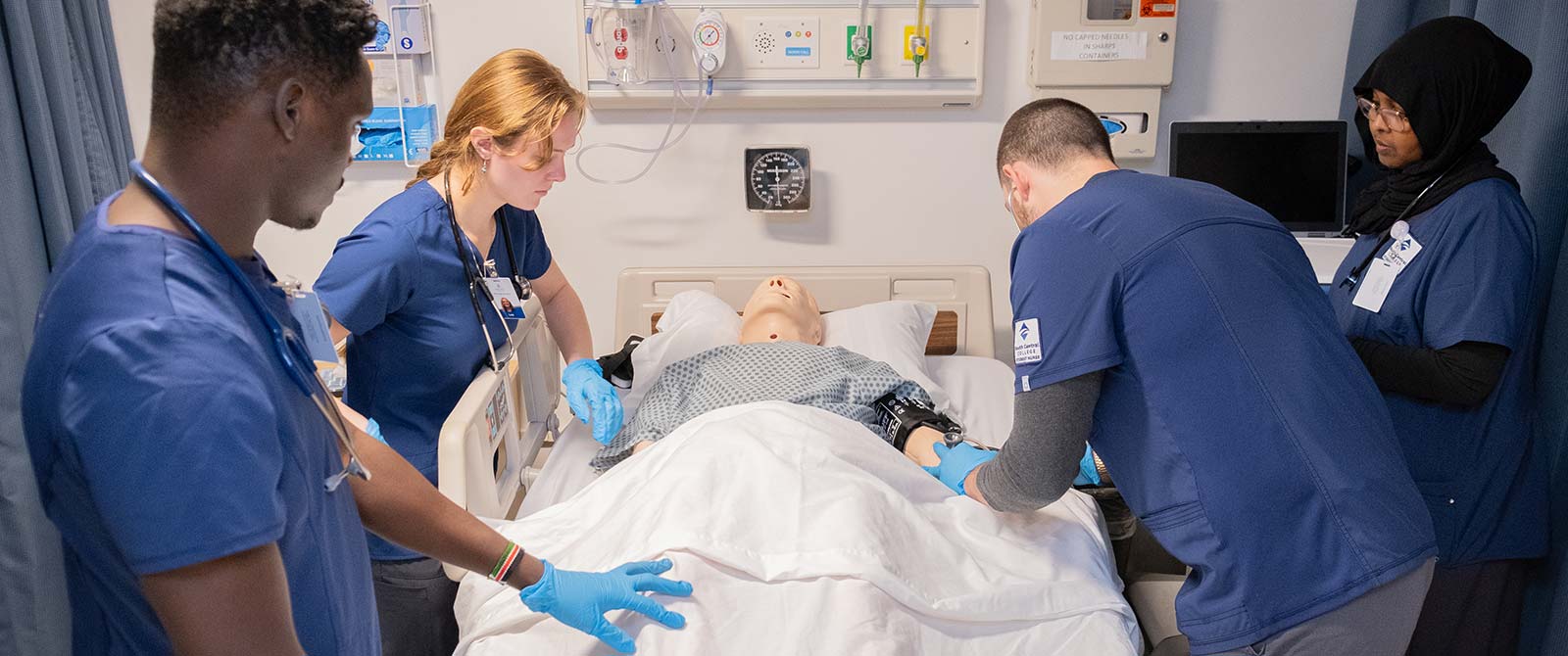 Group of nursing students working on a patient simulator